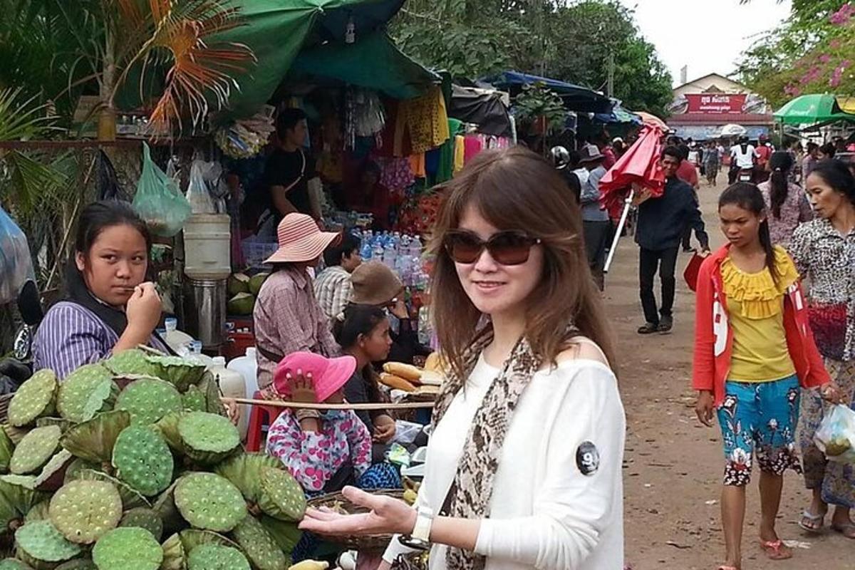 žena stojící na trhu s hromadou lidí