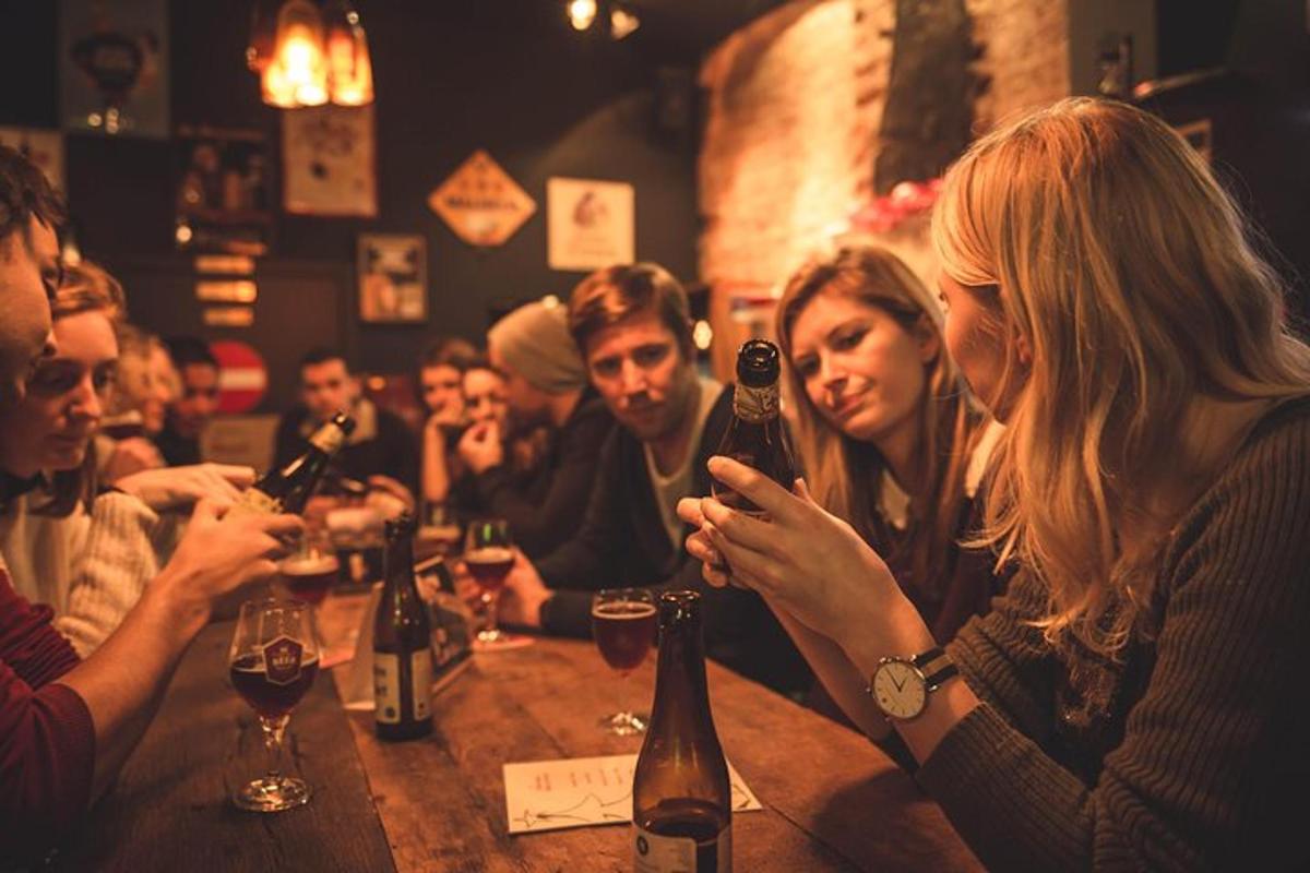 hópur fólks situr við bar með vínflöskur