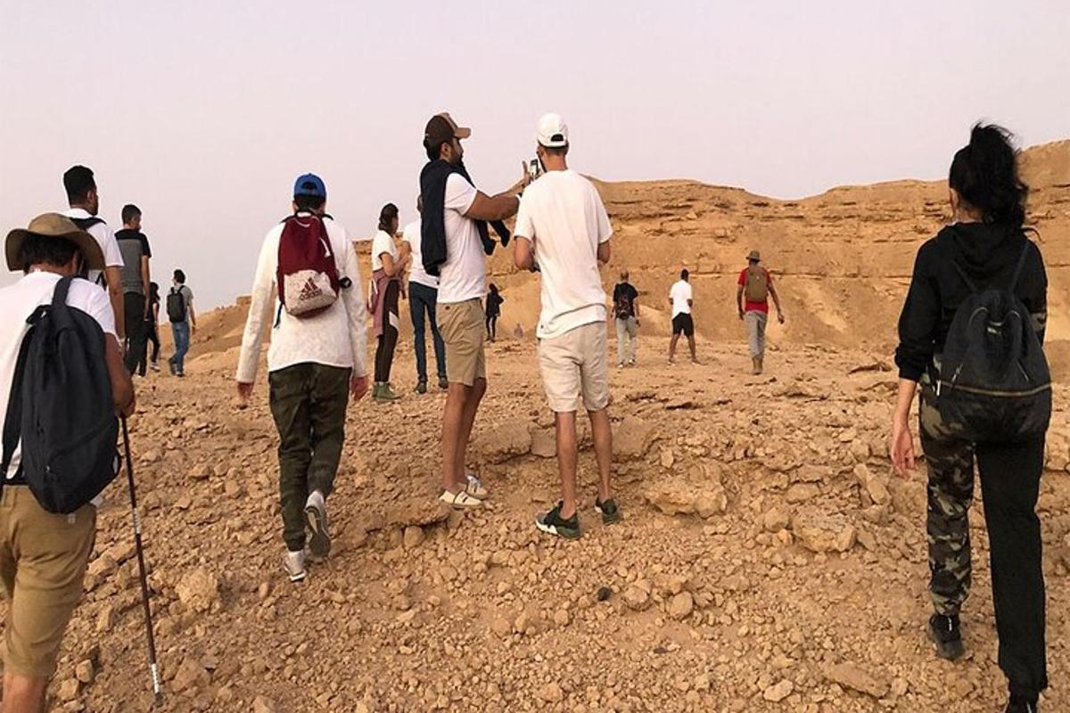 a group of people walking in the desert
