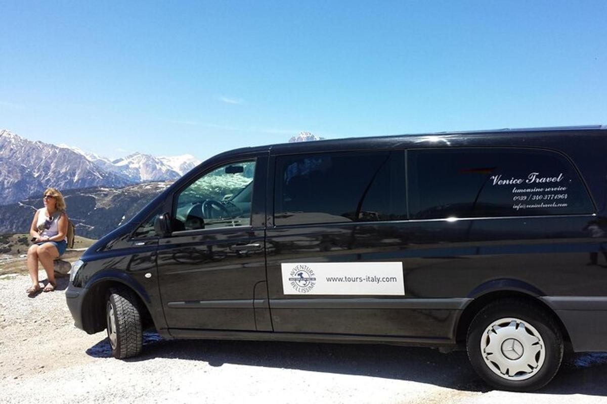 a woman is sitting next to a black van
