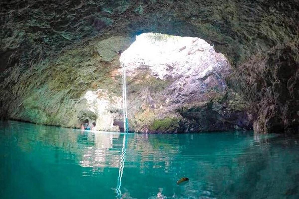 uma piscina de água em uma caverna com uma cachoeira