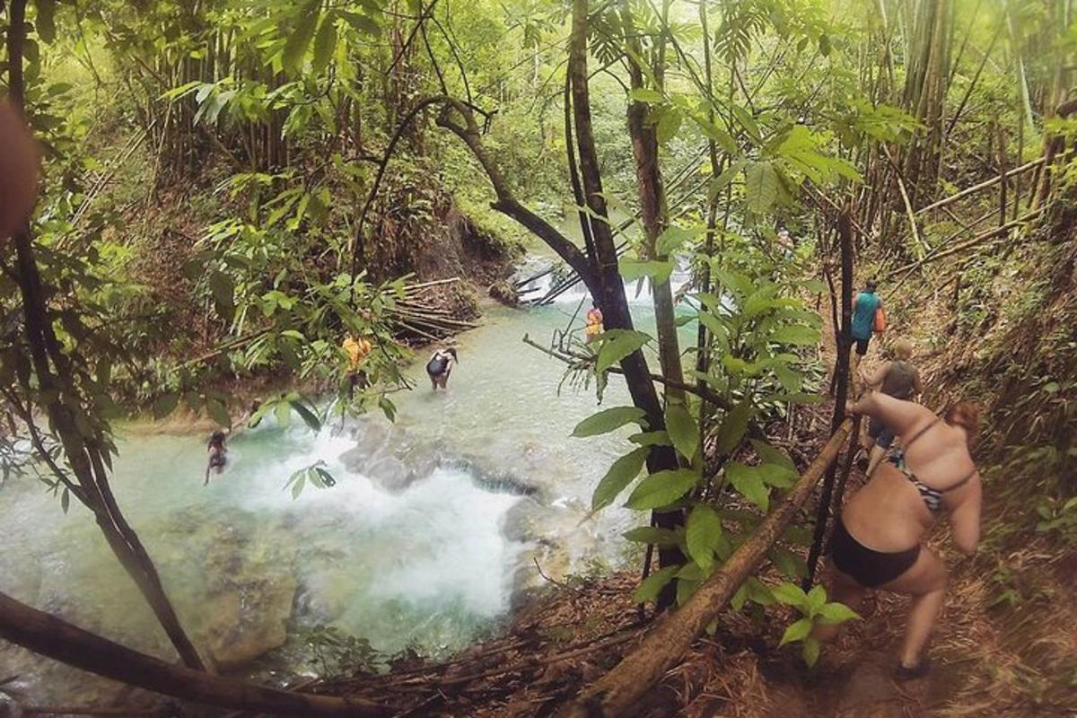um grupo de pessoas atravessando um rio na selva