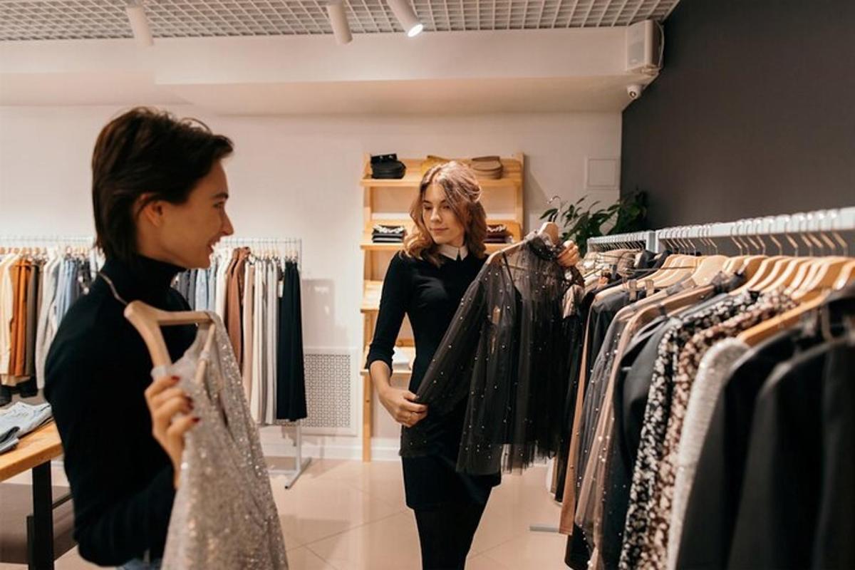 Dos mujeres mirando ropa en una tienda de ropa.
