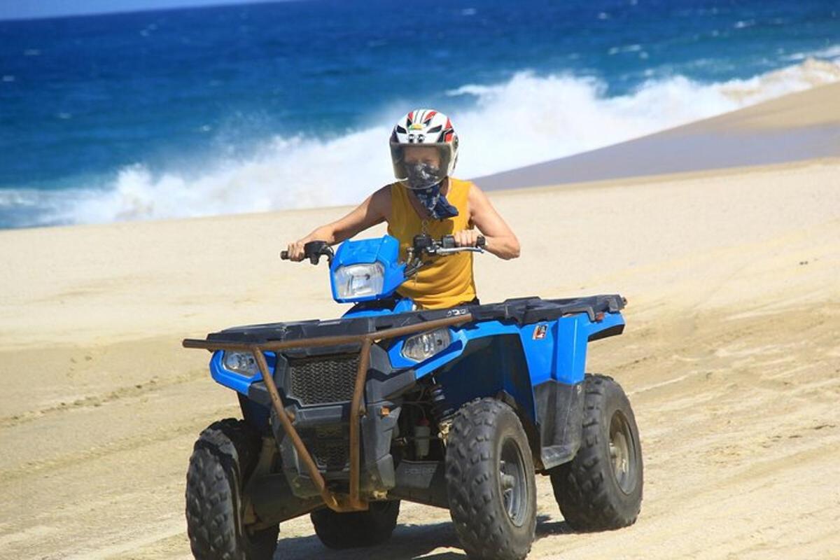 seorang budak lelaki menunggang basikal quad di pantai