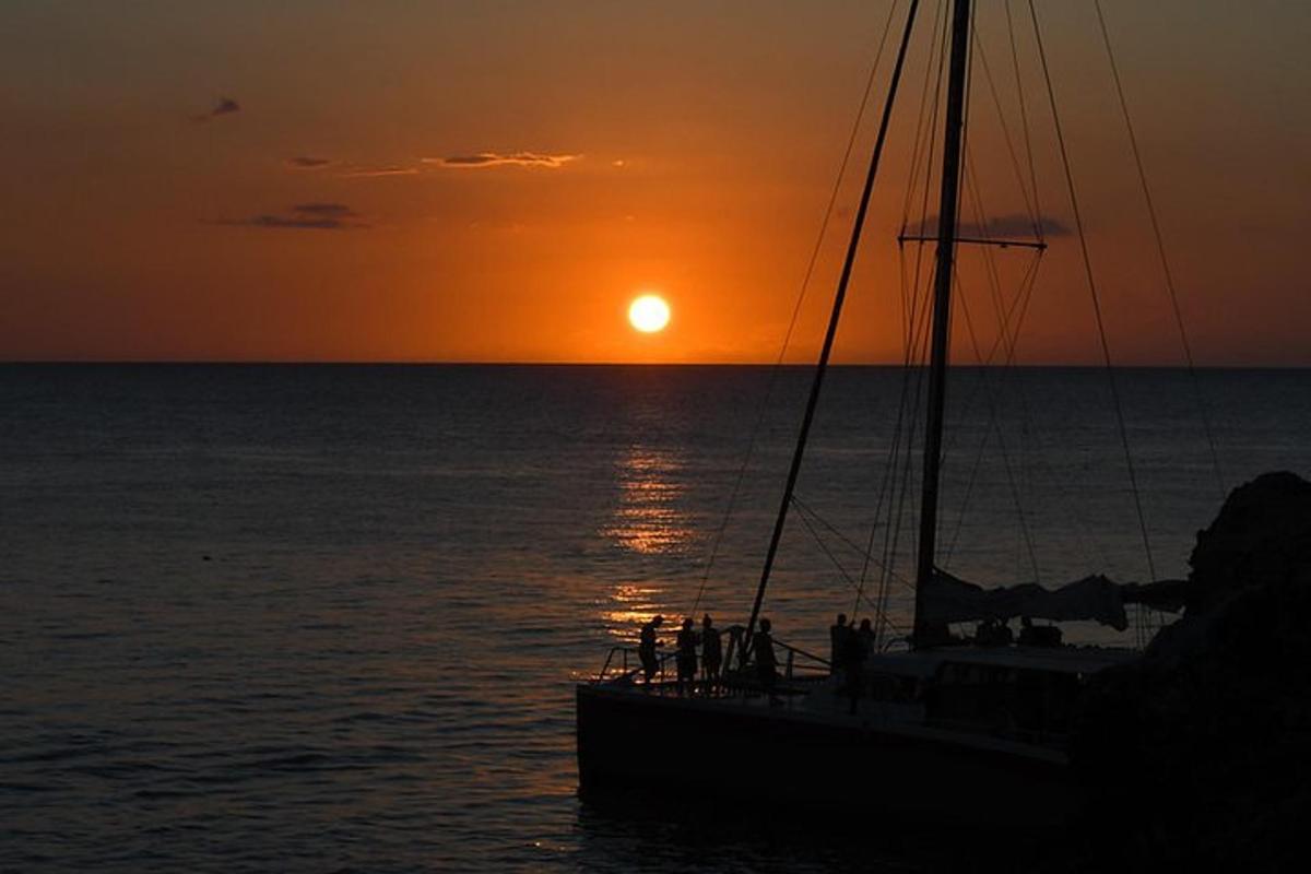 brod u oceanu sa zalaskom sunca u pozadini
