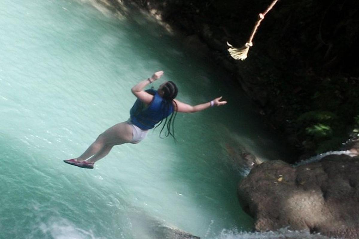 una donna sta saltando nell'acqua da una cascata
