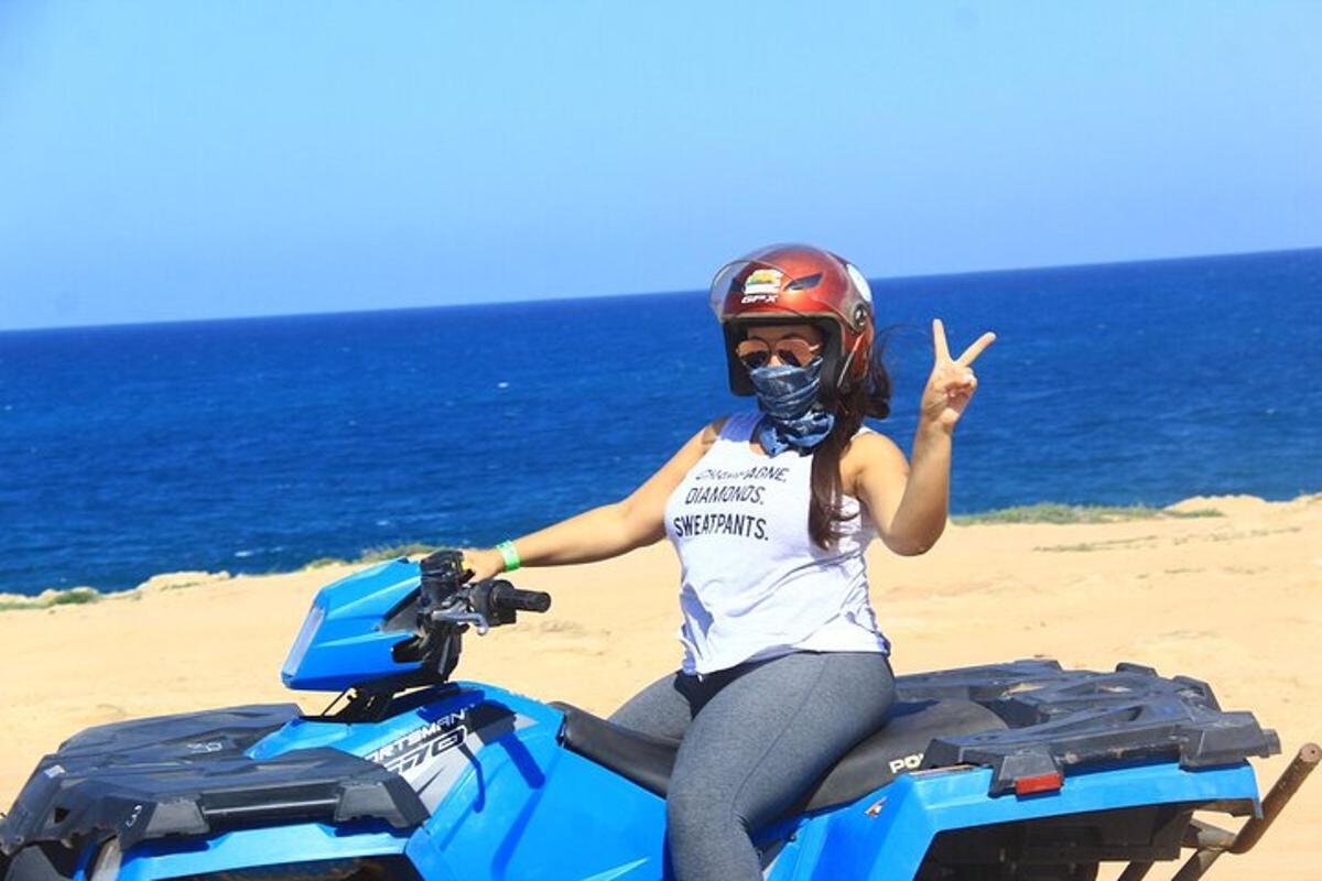 žena jedoucí na motorce na pláži