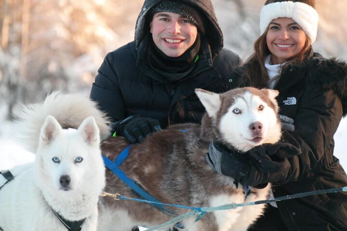 a man and a woman posing with two dogs