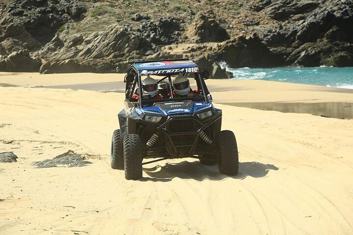 en blå ATV som kjører på en sandstrand
