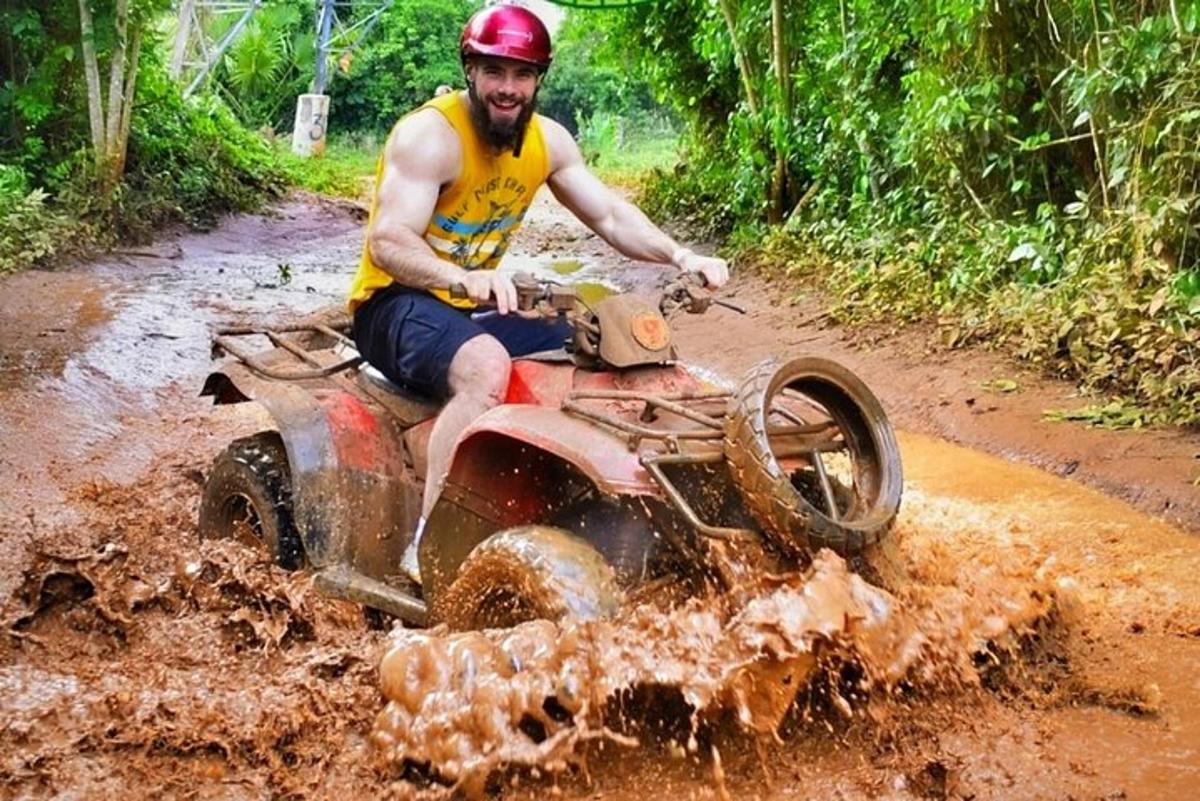 một người đàn ông đang lái xe địa hình trong bùn