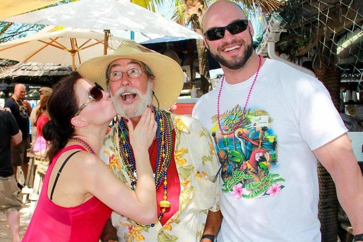 a woman is kissing a man in a hat