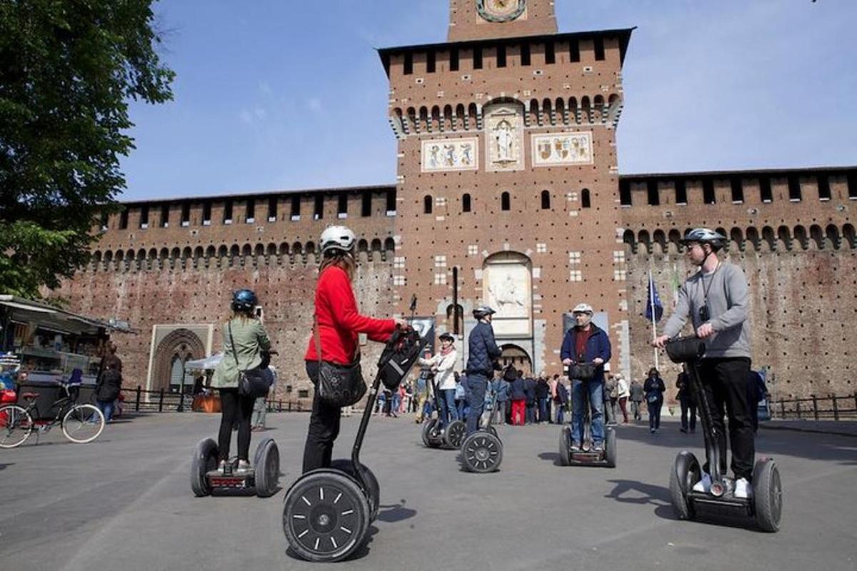 skupina ljudi, ki se vozijo na segwayih pred stavbo