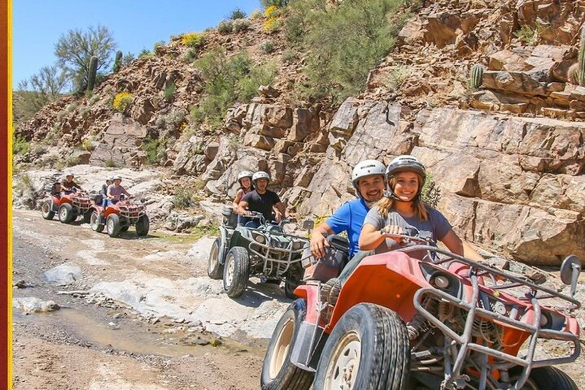 a group of people riding atvs down a dirt road