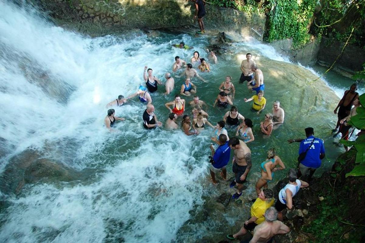 a group of people in the water on a waterfall