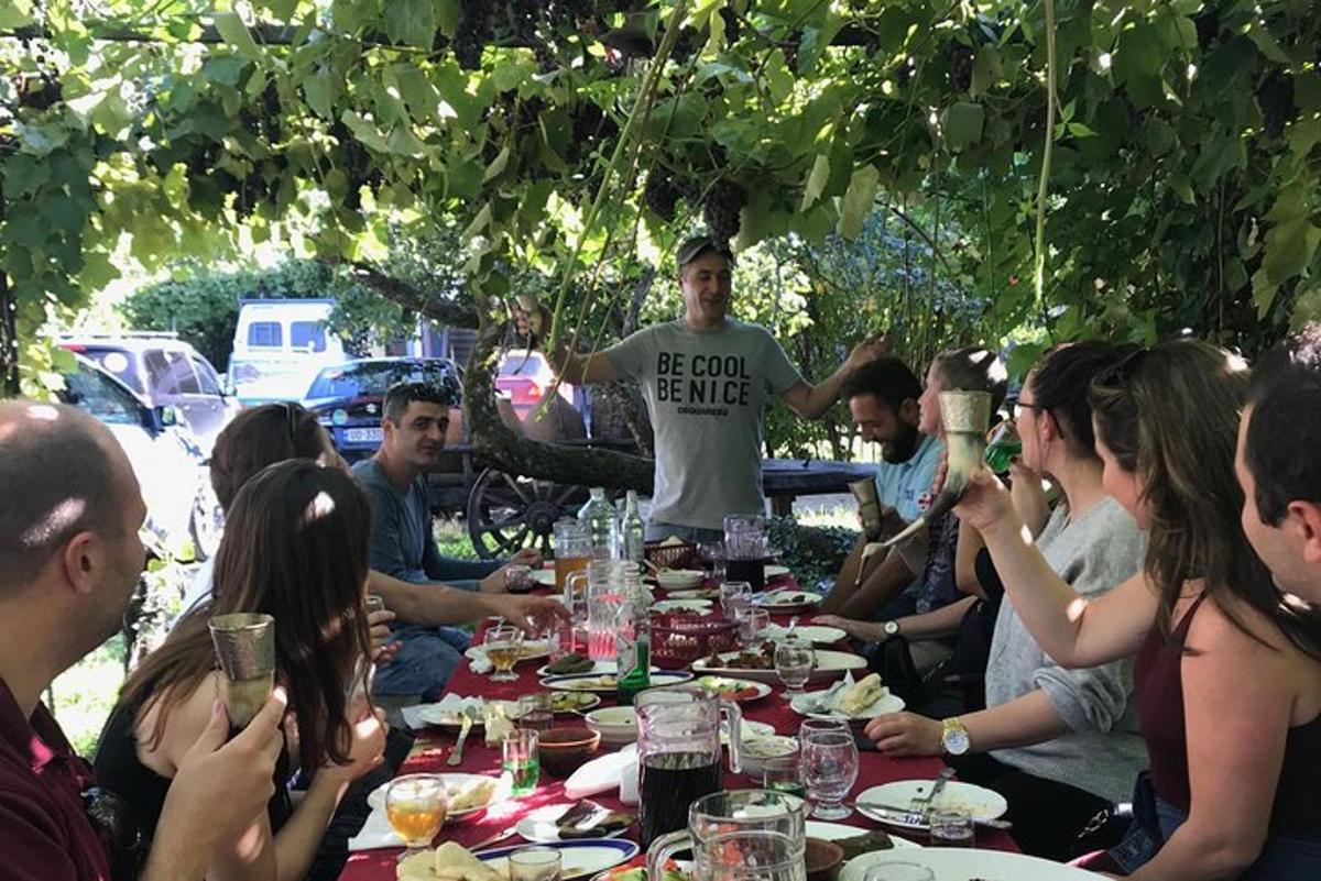 cilvēku grupa, kas sēž pie galda un ēd