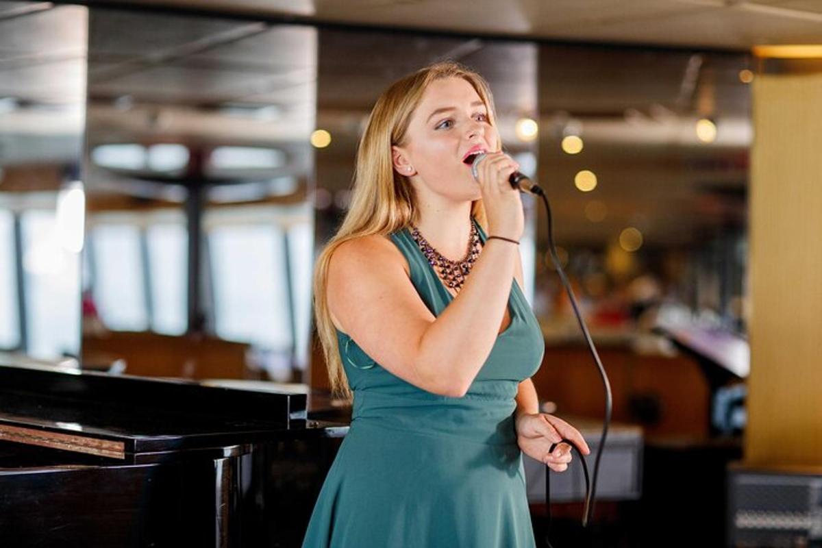 a woman in a green dress singing into a microphone