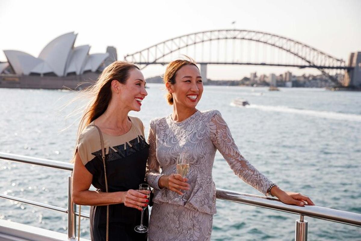 two women standing on a boat in front of the sydney opera house