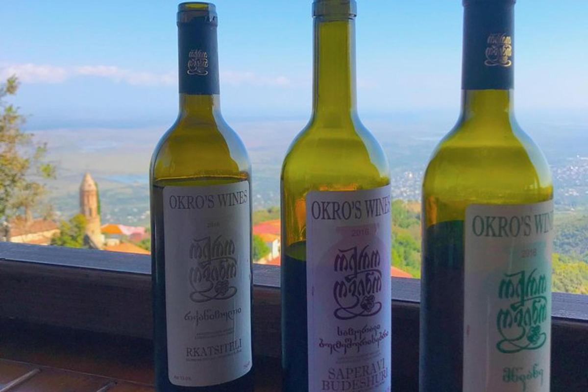 three bottles of wine sitting on a window sill