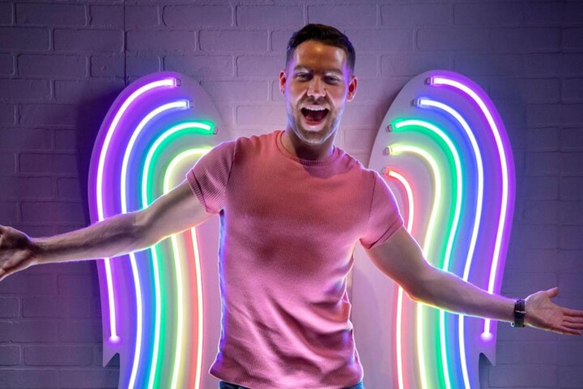 a man standing in front of a neon sign