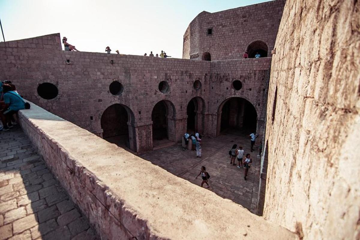 a group of people walking around a brick wall
