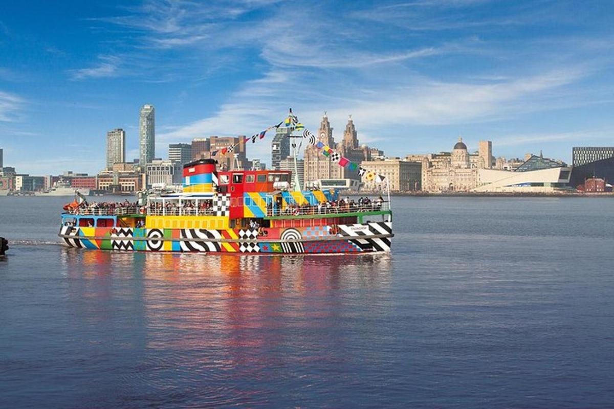 a colorful boat sitting in the water with a city