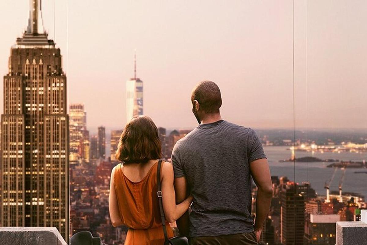 a man and woman standing on top of a skyscraper