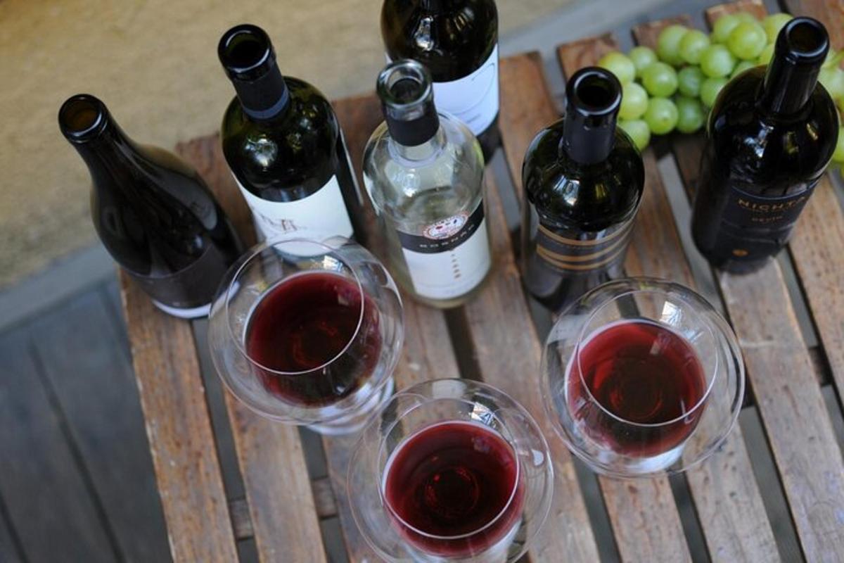 a group of wine bottles and glasses on a wooden table