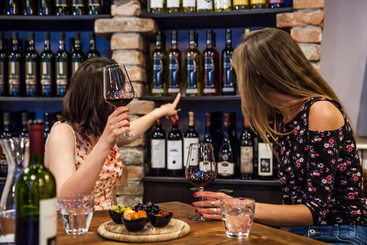 two women sitting at a bar drinking wine