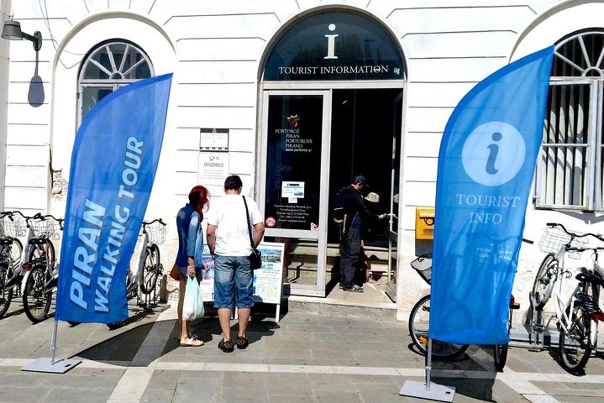 dvoje ljudi stoje ispred zgrade s biciklima
