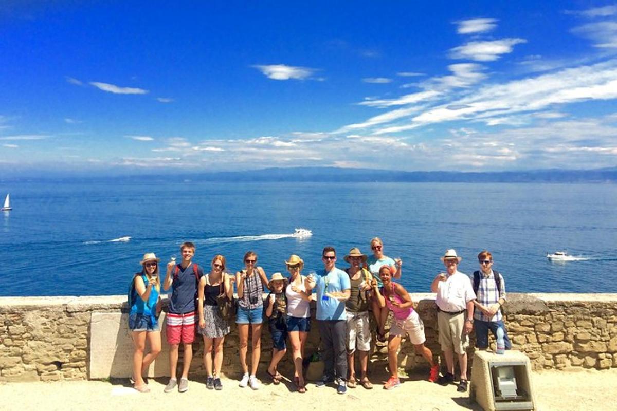un grup de persones posant per a una foto prop de l'oceà