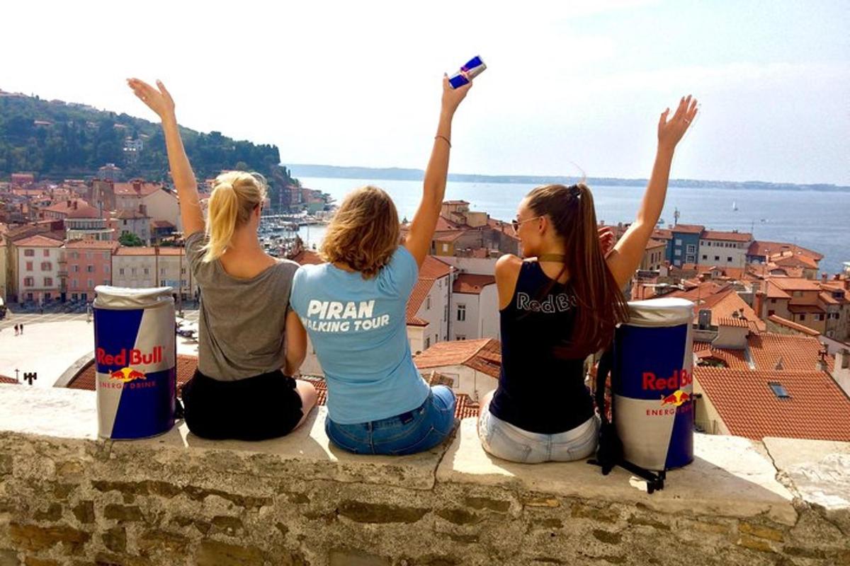 three women sitting on a wall looking at a city