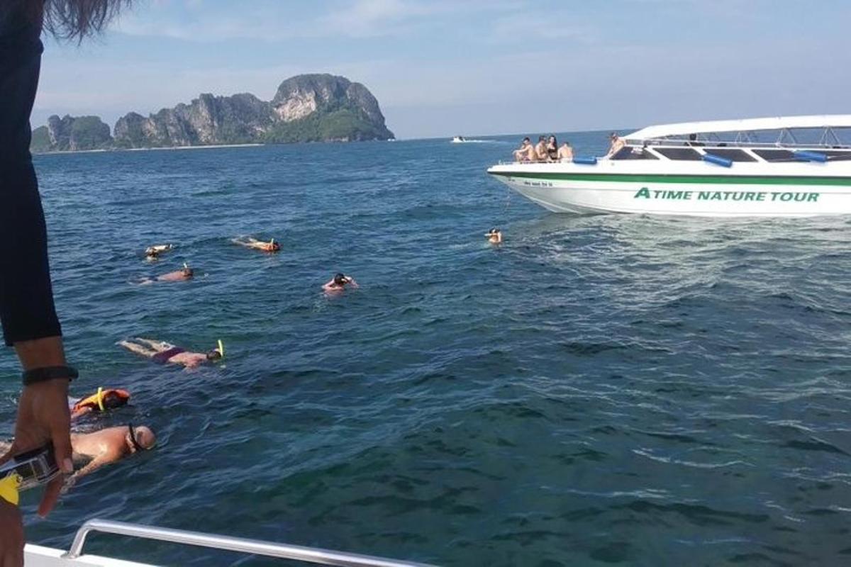 un grup de persones nedant a l'aigua al costat d'una barca