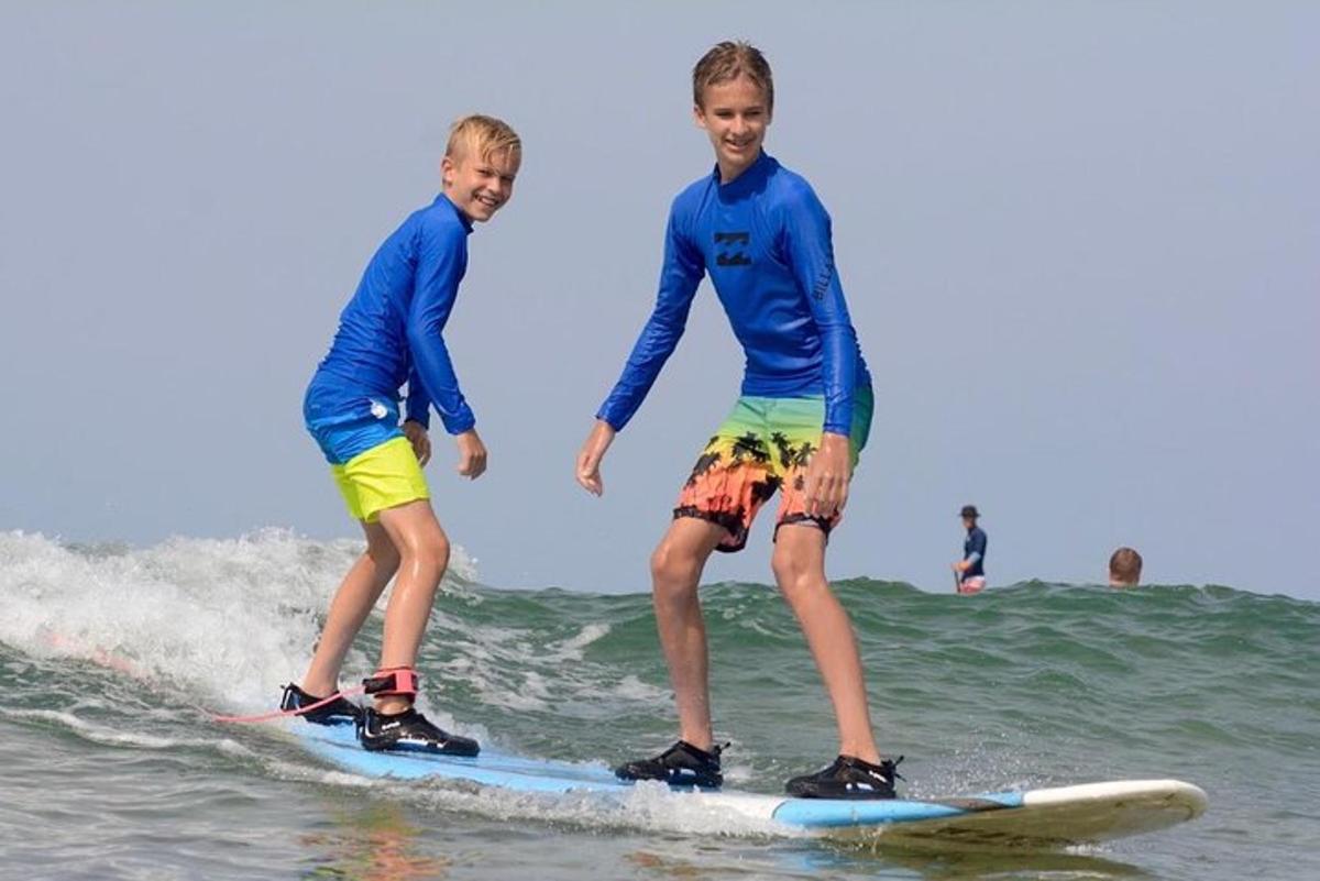 due ragazzi che cavalcano un'onda su tavole da surf nell'oceano