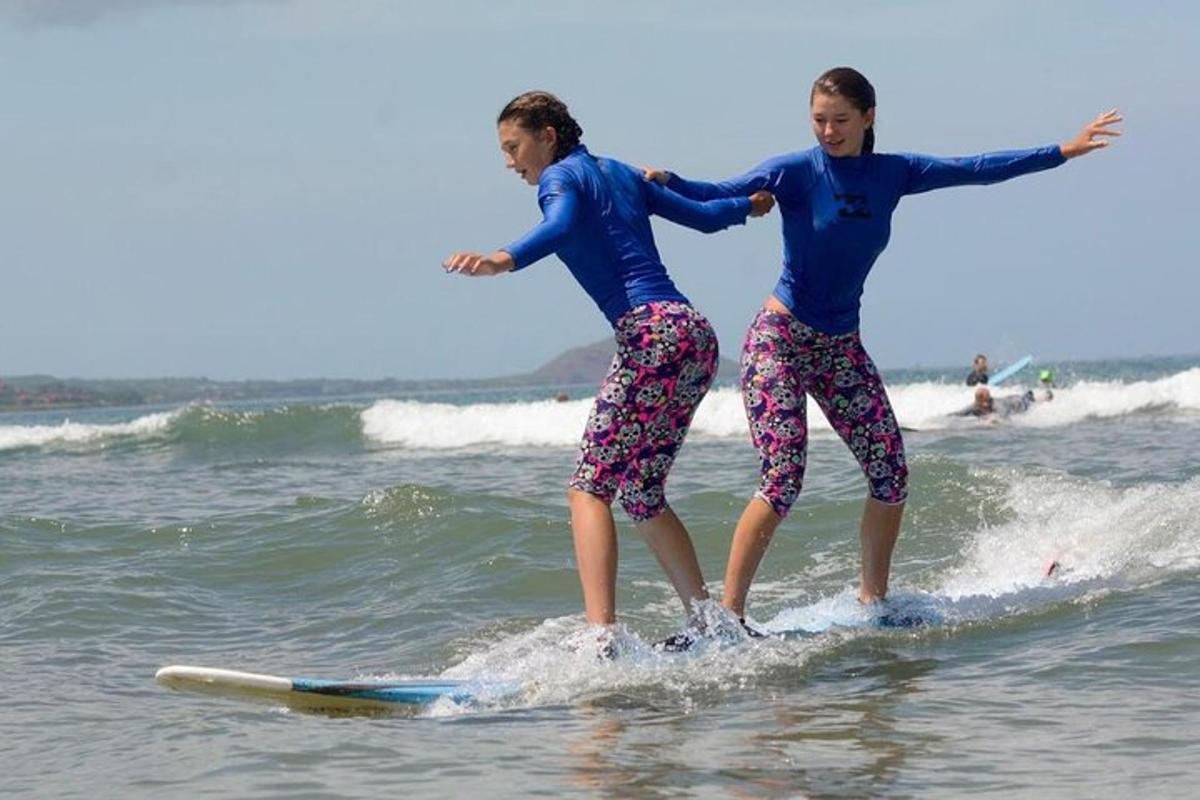 due ragazze sono in piedi su tavole da surf nell'oceano