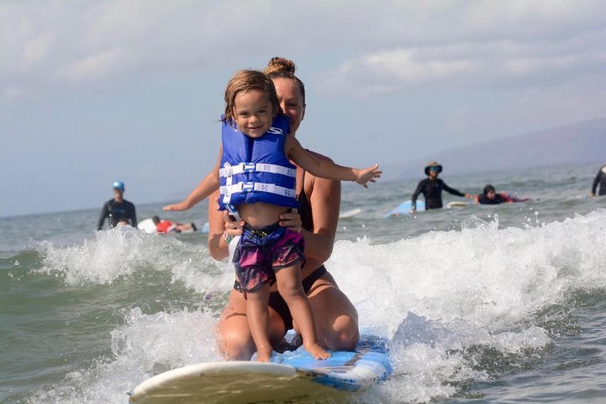 un uomo che tiene in braccio un bambino su una tavola da surf nell'oceano