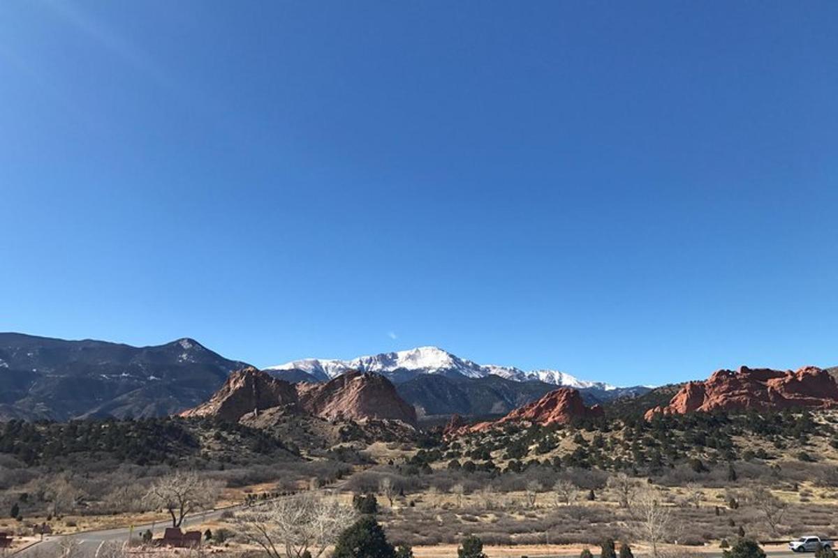 a view of the red rocks and snow capped mountains