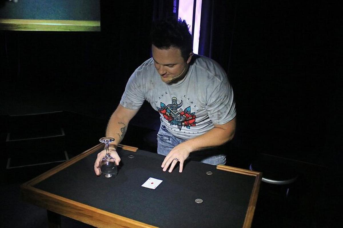a man standing next to a table with a bottle