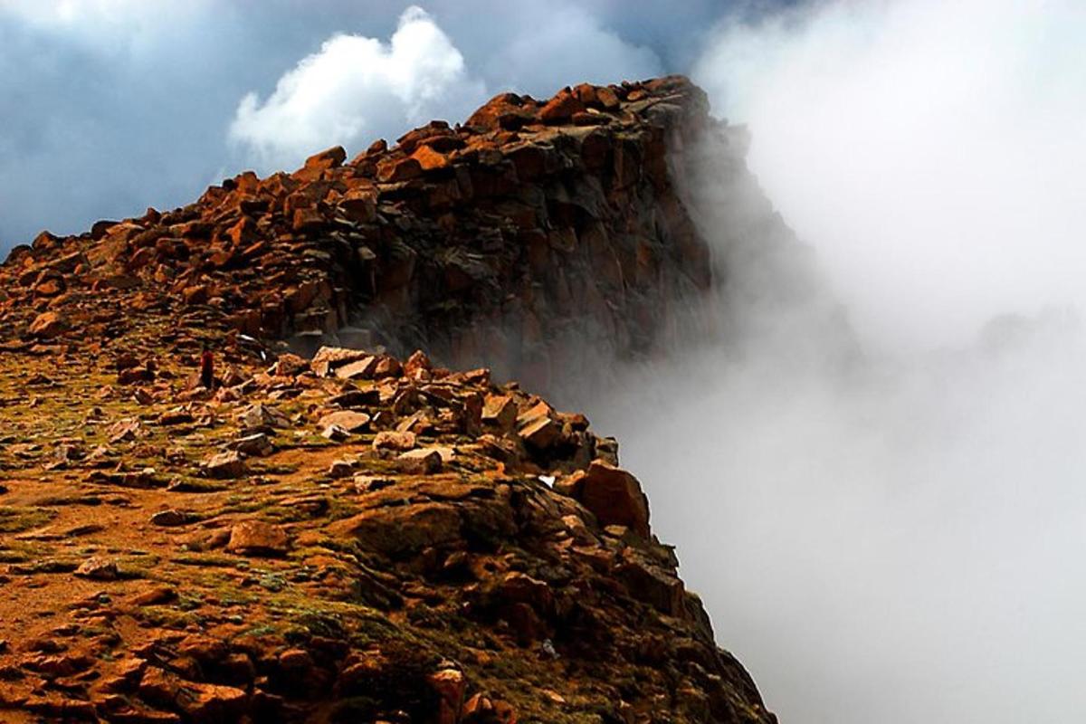 a rocky mountain with clouds on top of it