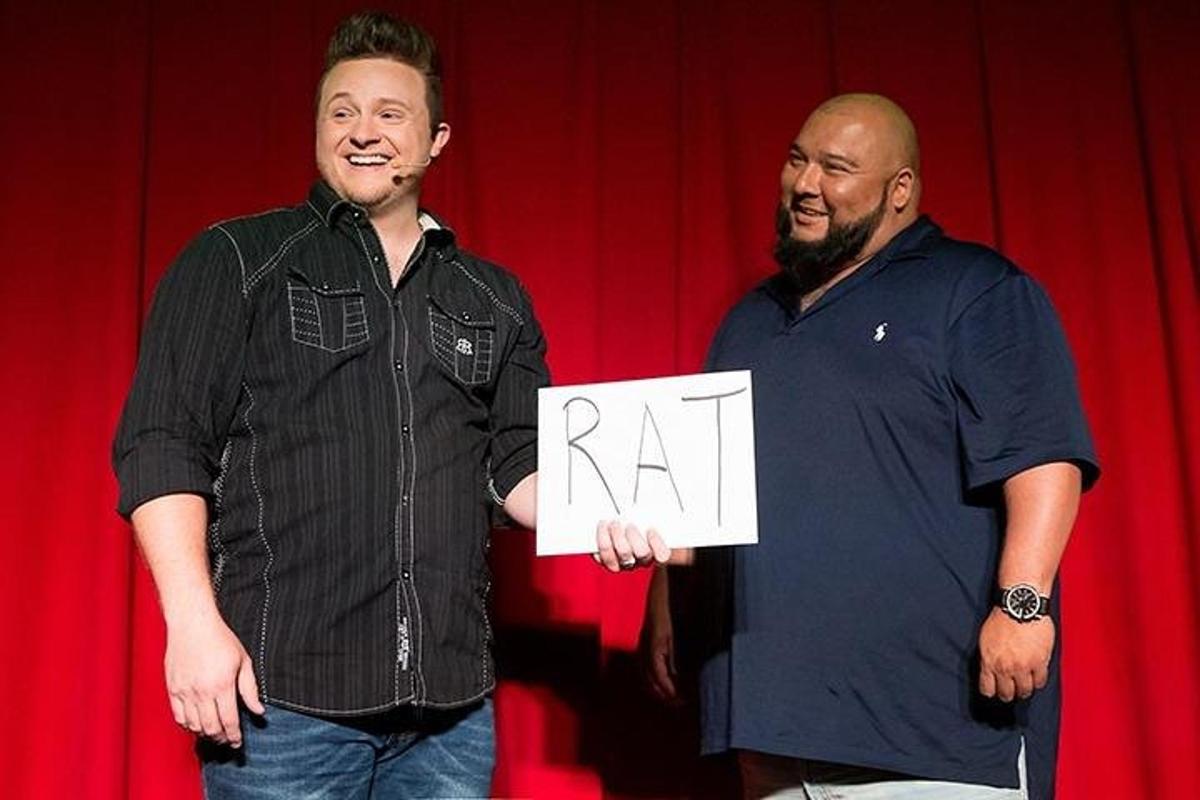 two men standing next to each other holding a ra sign