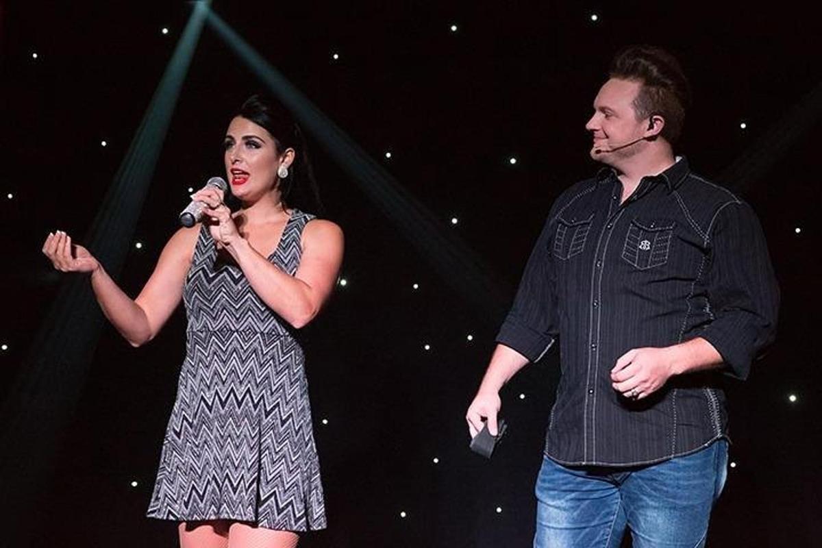 a man and a woman singing into a microphone on a stage