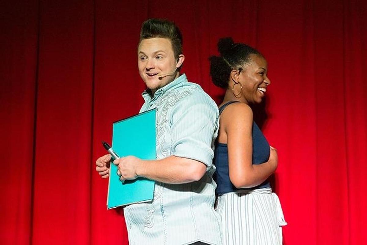a man and a woman standing in front of a red curtain
