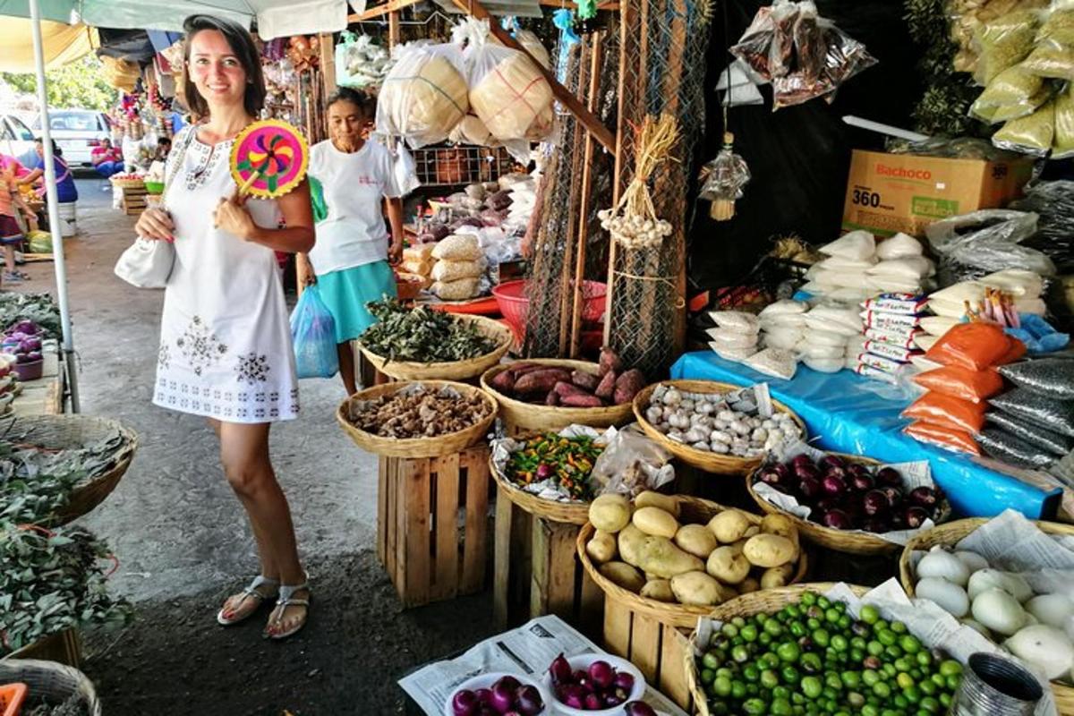 a woman standing in a market with fruits and vegetables