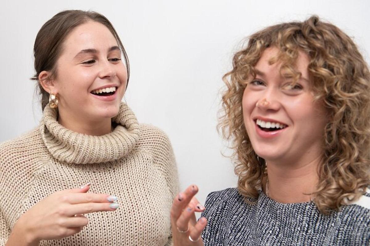 two women standing next to each other and laughing