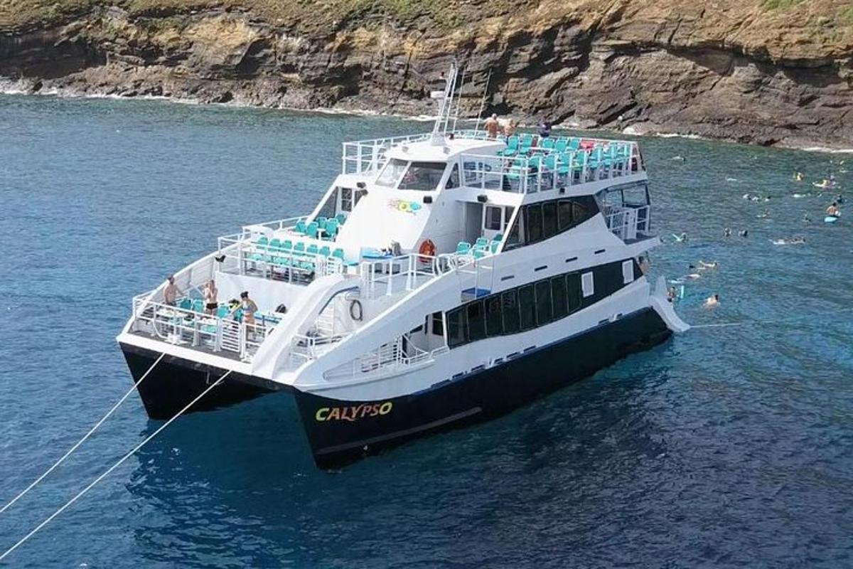 a ferry boat in the water near a cliff