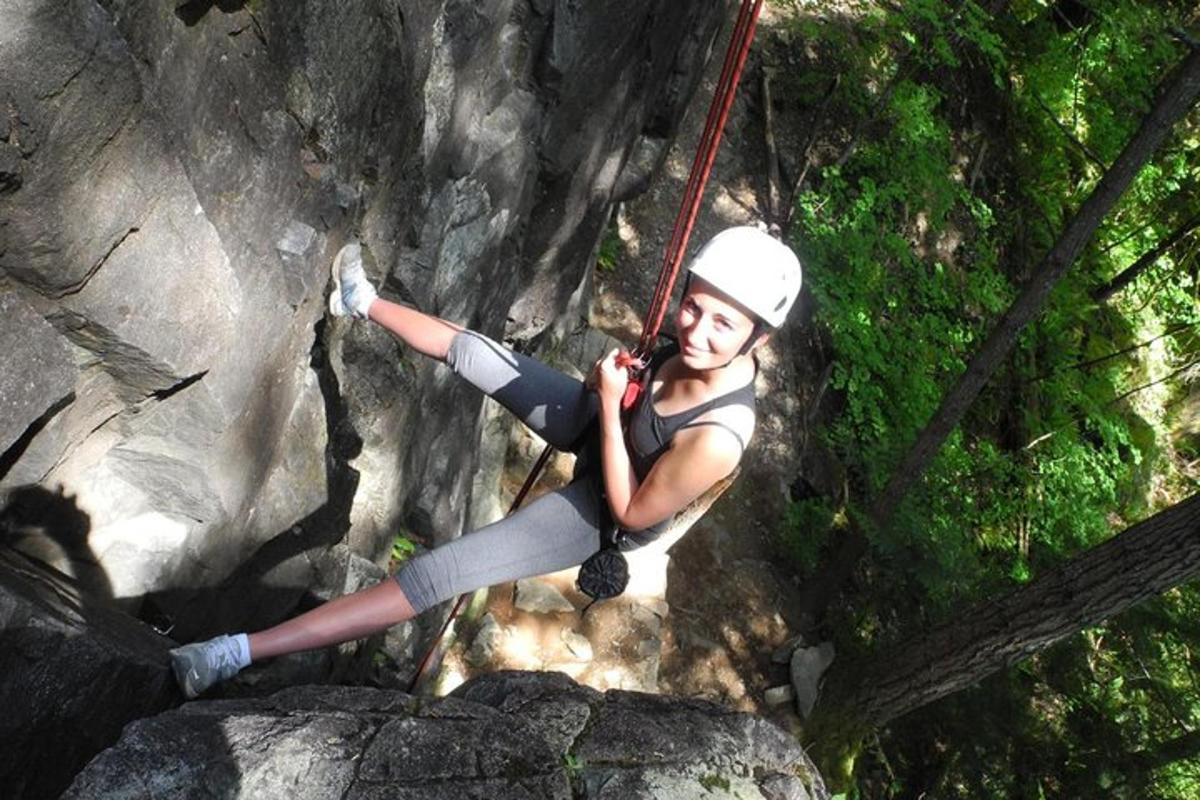 a woman is hanging on a rope while rock climbing