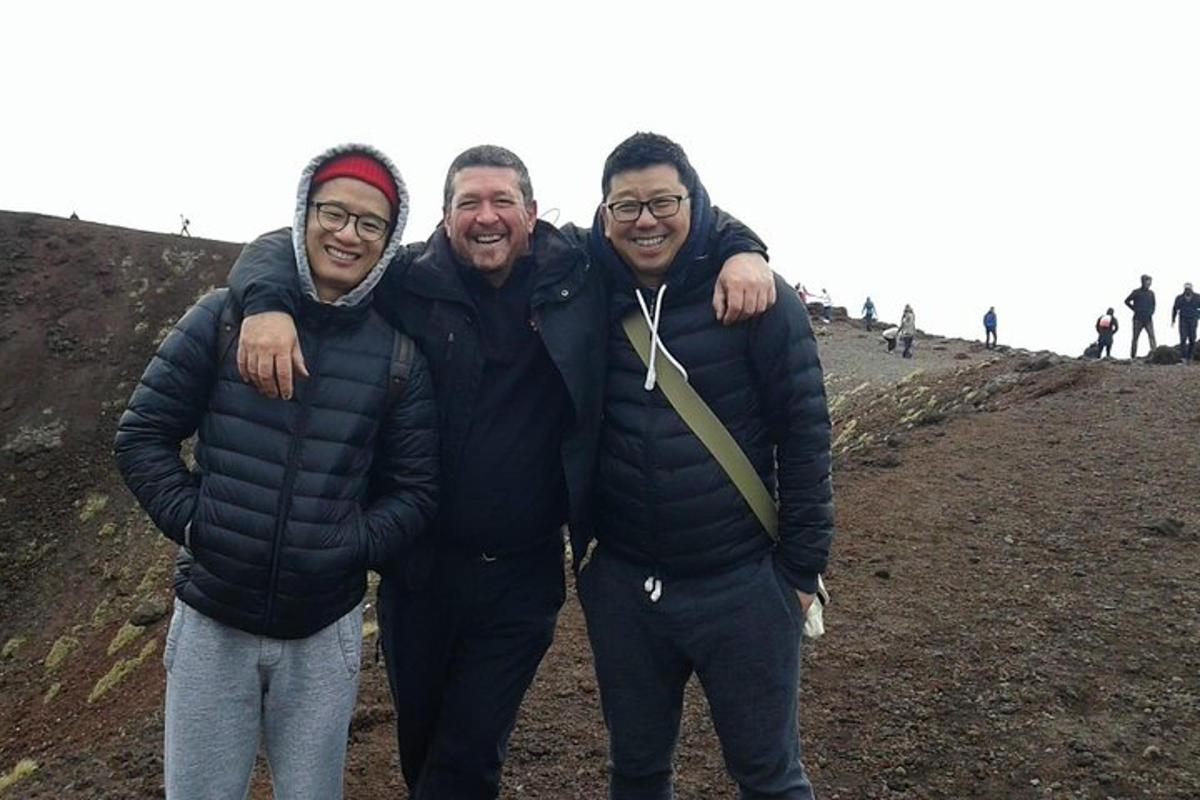 three men posing for a picture on a mountain