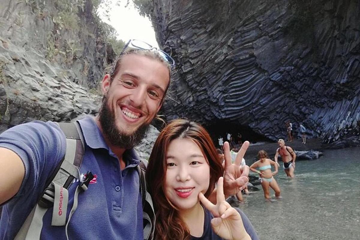Un hombre y una mujer haciendo el signo de la paz en una cueva.