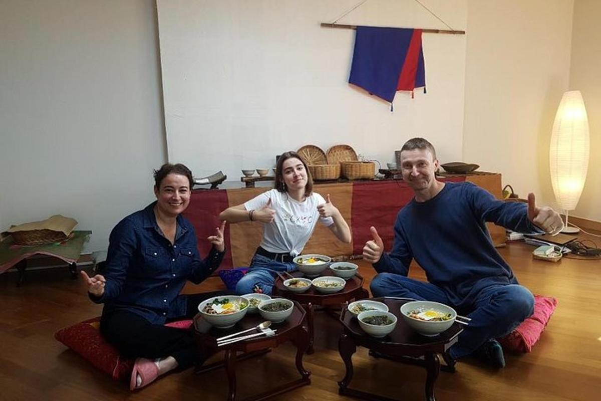 a group of people sitting on the floor with bowls of food