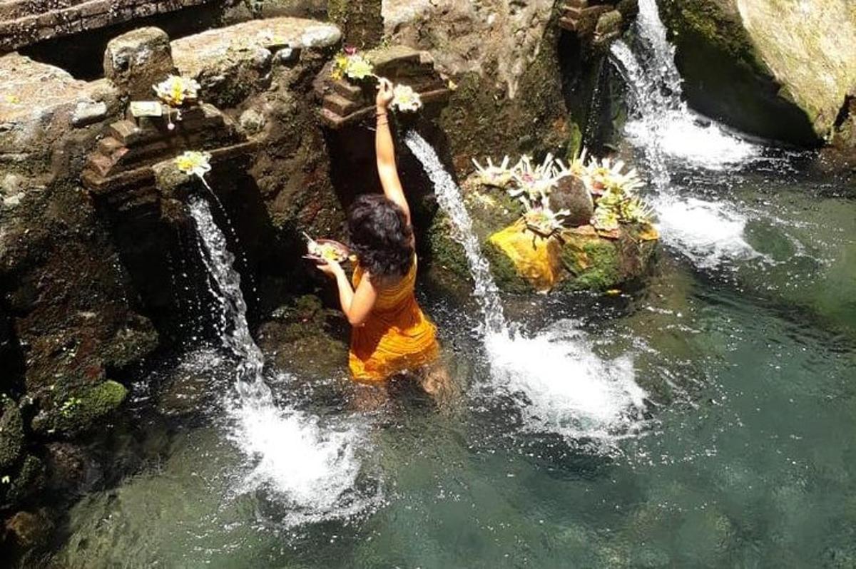 una persona in piedi nell'acqua vicino a una cascata