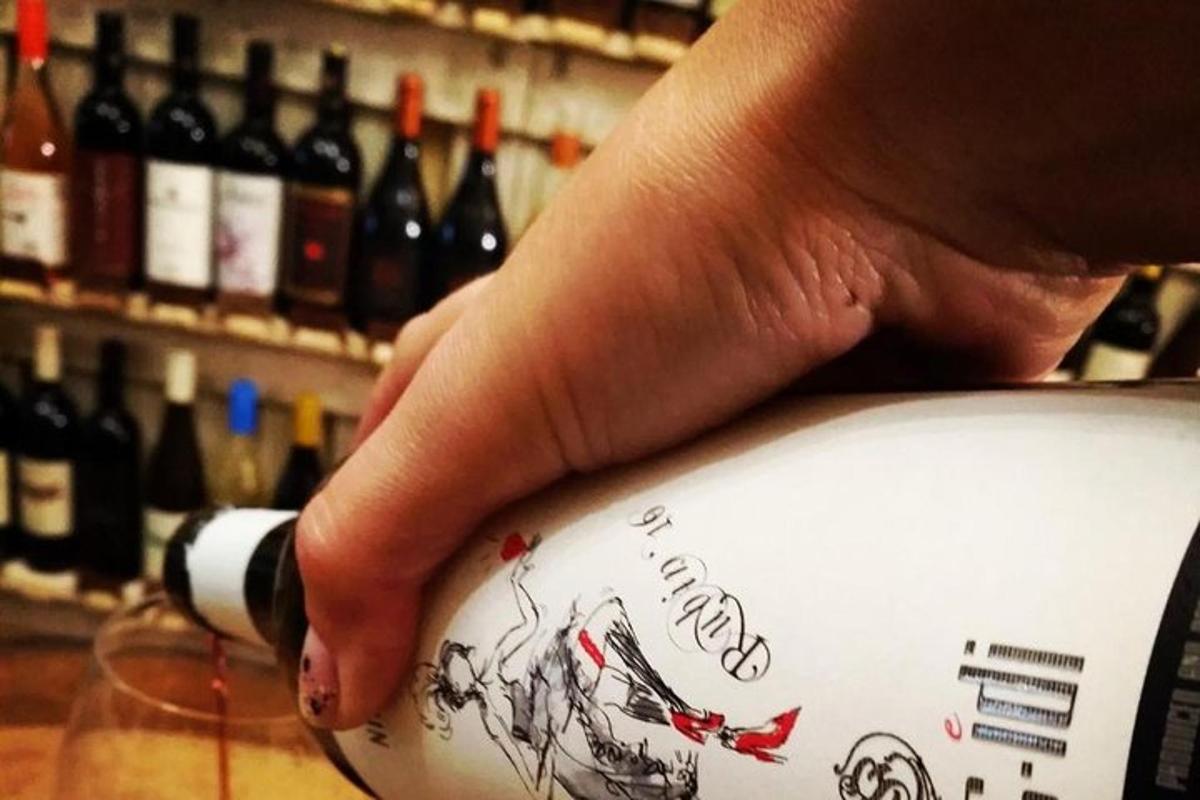 a person is pouring wine into a wine glass